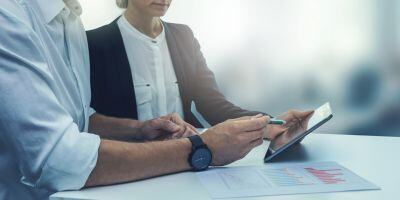 Woman and man reviewing data on tablet