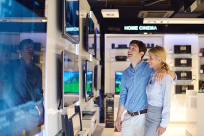 people in consumer electronics  retail store looking at latest laptop, television and photo camera to buy trade and shipping