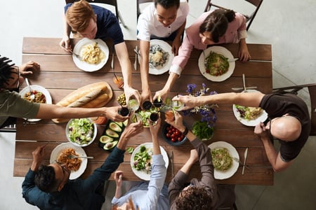 people surrounding a table with a meal provided by the food supply chain