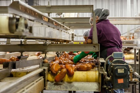 worker inspecting produce in the food supply chain