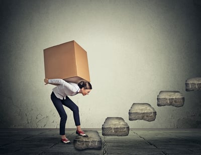 Difficult task perspective concept. Young slim woman carrying large heavy box on her back upstairs freight budget