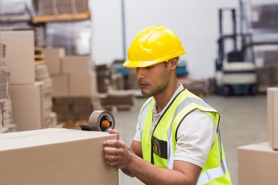 Worker in warehouse preparing consumer packaged goods