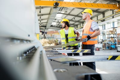 workers in nearshoring warehouse with heavy machinery