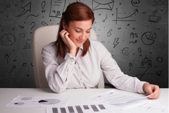 Woman at desk looking at charts